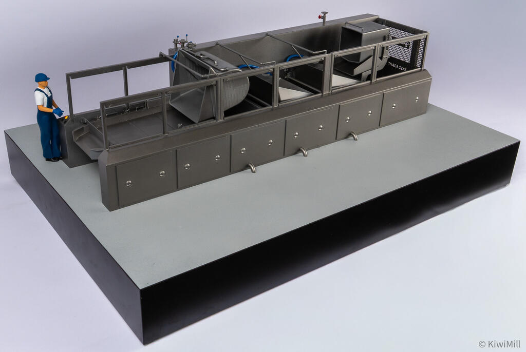 Three-quarter view of the cooking line model from the loading end, worker figure at the control panel